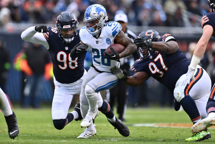 Dec 10, 2023; Chicago, Illinois, USA; Detroit Lions running back Jahmyr Gibbs (26) picks up yardage before being tackled by Chicago Bears defensive lineman Montez Sweat (98) and defensive lineman Andrew Billings (97) in the first half at Soldier Field. Mandatory Credit: Jamie Sabau-USA TODAY Sports